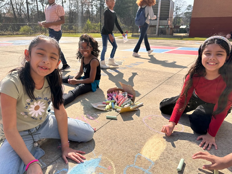 Girls in WINGS program create a sidewalk mural