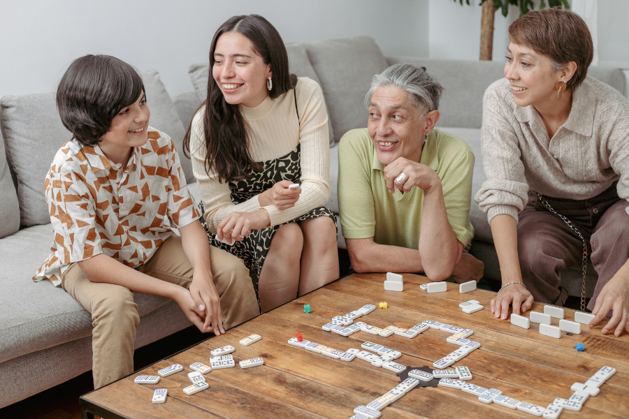 Multi-generational family plays a game of dominos together